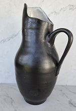 Load image into Gallery viewer, Matte black pitcher with a pulled spout showing a glossy interior, a curved handle, and a rounded body.