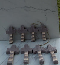 Load image into Gallery viewer, Seven rustic wooden crosses arranged on a marble-patterned surface. Each cross has three white stripes on the bottom section of the crosses.