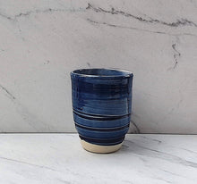 Load image into Gallery viewer, The outside of the tumbler has a royal blue glaze with a white glazed inside and an unglazed base.
