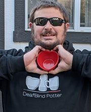Load image into Gallery viewer, Deafblind Potter with a small (not mini) heart bowl in his hands in a shape of a heart 
